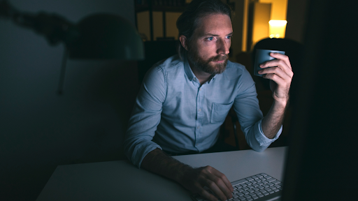 A man working on his computer in the dark