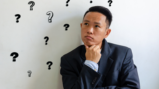 A man thinking with question marks around him
